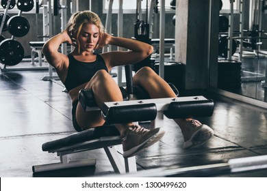 Attractive Young Woman Doing Sit Up Exercise With Machine At The Gym.