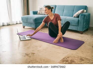 Attractive young woman doing yoga stretching yoga online at home. Self-isolation is beneficial, entertainment and education on the Internet. Healthy lifestyle concept. - Shutterstock ID 1689673462
