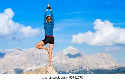 An Attractive Young Woman Doing A Yoga Pose For Balance And Stretching High In The Mountains