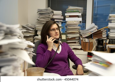 Attractive Young Woman Executive At Work In A Very Messy Office