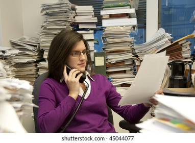 Attractive Young Woman Executive At Work In A Very Messy Office