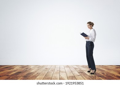 Attractive young woman in formal wear is holding a notebook and pondering how to optimize business process to boost sales of the company. Full length business woman.  - Shutterstock ID 1921953851