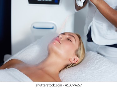 Attractive young woman getting local cryotherapy therapy at cosmetology clinic. Applying cold nitrogen vapors to the face of woman.