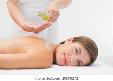 Attractive Young Woman Getting Massage Oil On Her Back At Spa Center