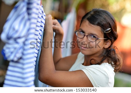 An attractive young woman hanging laundry.