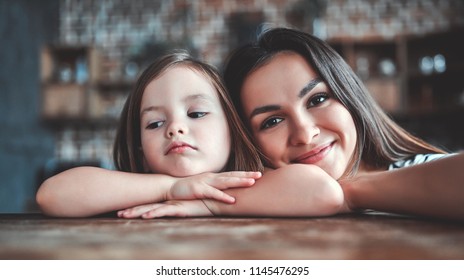 Attractive Young Woman And Her Little Cute Daughter Are On Kitchen. Mom And Girl Are Tired After Cooking.