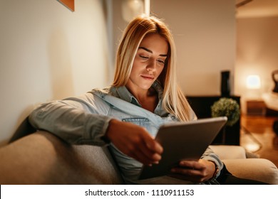 Attractive young woman holding a tablet at home - Powered by Shutterstock