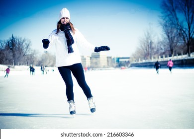 Attractive Young Woman Ice Skating During Winter