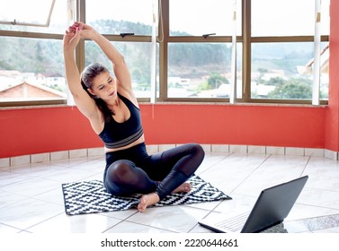 Attractive Young Woman Learning New Exercises With Online Fitness Lessons