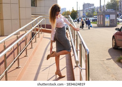 Attractive Young Woman Looking At Broken Stiletto Heel On Her Shoe.