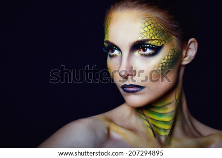 Attractive young woman in makeup snake shot in the studio