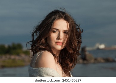 Attractive young woman model with brown hair and natural make-up walking along the shore of the resort on a spring morning. Happiness, balance, tranquility, emotion and mood concept - Powered by Shutterstock