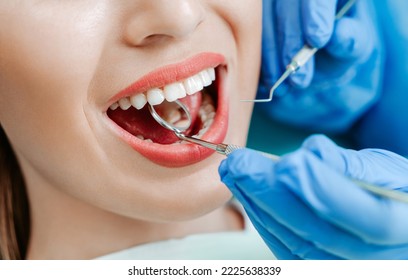 Attractive young woman with natural white teeth in dental clinic. Hands doctor dentist with medical tools. Healthy teeth concept - Powered by Shutterstock