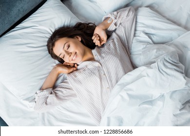 Attractive Young Woman In Pajamas Waking Up In Bed In The Morning