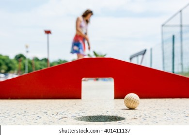 Attractive Young Woman Playing Mini Golf.