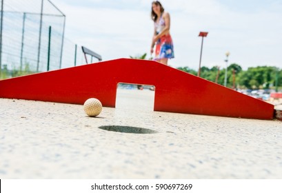 Attractive Young Woman Playing Mini Golf.