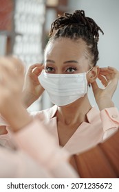 Attractive Young Woman Putting On Protective Mask Before Leaving Her House