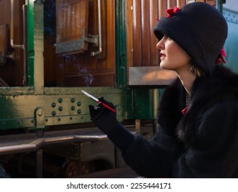 Attractive young woman in red 1920s flapper dress and cloche hat travelling by antique steam train - Powered by Shutterstock