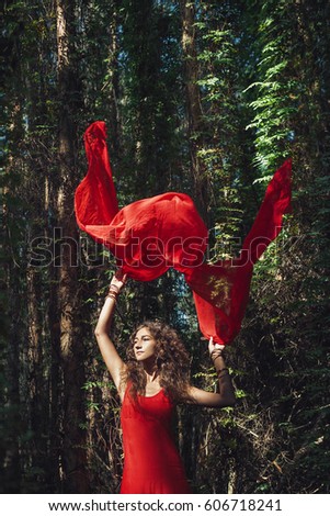 attractive young woman in red dress in forest
