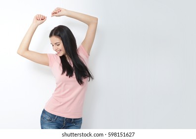 Attractive Young Woman Relax And Dance On Copy Space. Portrait Of Happy Girl Dancing Your Hands Up On White Background