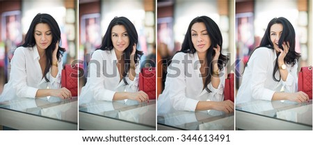 Attractive young woman sitting on a table in shopping center. Beautiful fashionable young lady in white shirt in mall. Casual long hair brunette posing smiling and teasing, indoors shot