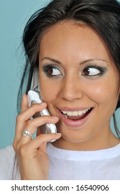 Attractive Young Woman Smiling While Holding Her Mobile Cell Phone To Her Ear And Mouth