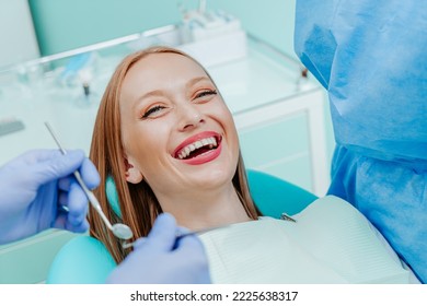 Attractive young woman smilling with natural white teeth in dental clinic. Hands doctor dentist with medical tools. Healthy teeth concept - Powered by Shutterstock