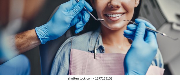 Attraktive junge Frau in der Stomatologie-Klinik mit männlichem Zahnarzt. Gesundes Zahnkonzept.