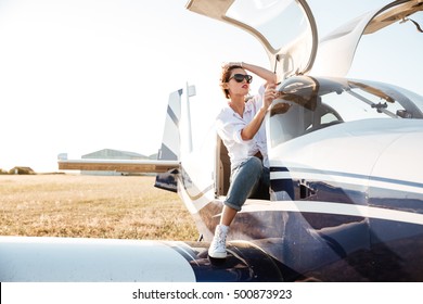 Attractive Young Woman In Sunglasses Sitting In Small Private Plane
