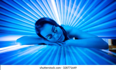 Attractive Young Woman Tanning In Solarium And Smiling.