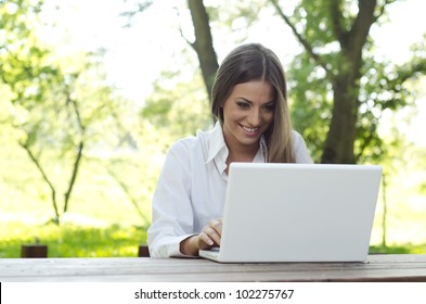 Attractive Young Woman Using Laptop Outside