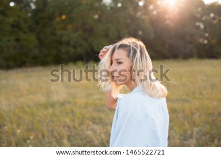 Attractive young woman walking outdoors under sunlight