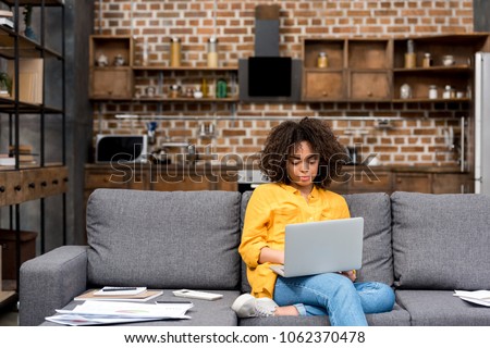 Photo of attractive young woman working working with laptop on couch