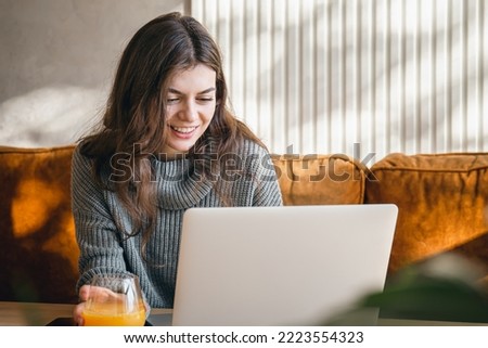 Attractive young woman working on a laptop early in the morning.