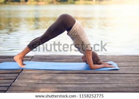 Similar – Active slim young woman doing yoga by the lake