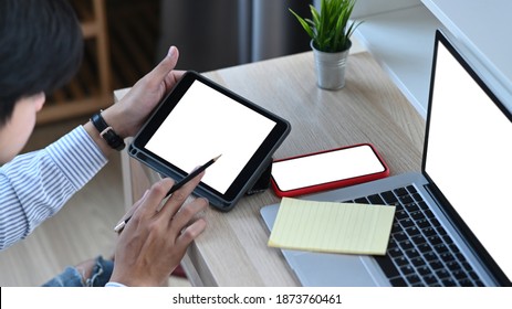 Attractive Younng Man Working With Multiple Electronic Internet Devices At Office.