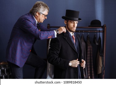  ature professional tailor fitting bespoke suit to male model in exclusive atelier studio