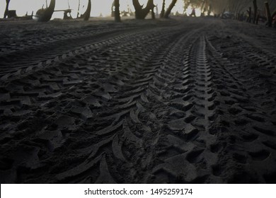 ATV Motorcycle Tires On Black Sand Top View
