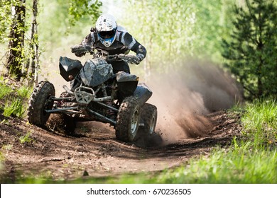 ATV rider creates a large cloud of dust and debris on sunny day