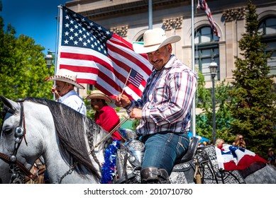 AUBURN, CA, U.;S.A. - JULY 4, 2021: Photo of one of the members of the Los Caballeros de Auburn on his white horse.  The Hispanic cowboy contingent features music, dancing, and horse riding.