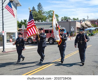 AUBURN, CA, U.;S.A. - JULY 4, 2021: Photo of four members of the Auburn Honor Guard bearing flags at the beginning of the small town's July 4 parade.