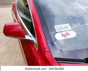 AUBURN, CA/U.S. - MARCH 8. 2020:  Photo Of A Red Model 3 Tesla Electric Car With Uber And Lyftt Ride-sharing Sticker Placards In The Windshield.