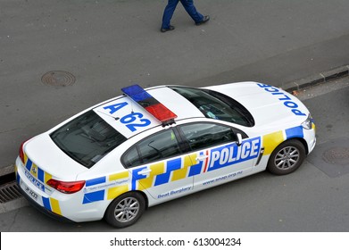 AUCKLAND - MAR 30 2017:Aerial View Of An Unrecognizable New Zealand Police Officer Patrolling Beside A Police Car During A Crime Response In Auckland, New Zealand.