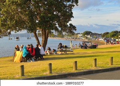 Auckland, New Zealand - January 1, 2021: Group Of People Sitting Around Table For Outdoor Meal At Bucklands Beach