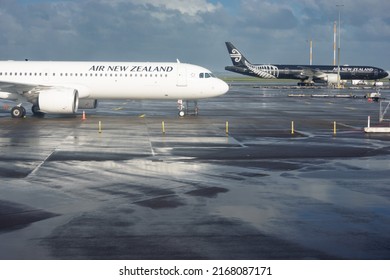 Auckland New Zealand - June 13 2022: White and black Air New zealand planes parked on tarmac. at Auckland Airport after rain.