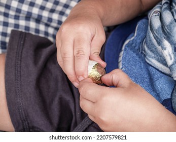 Auckland New Zealand - March 21 2009; Child’s Hand Close In Unwrapping Small Chocolate Easter Egg.