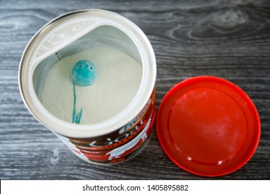 Auckland, New Zealand - May 22 2019: Tin Of Fresco Nutrition Goat Based Formula For Infants From Birth. 900gm Tin With Red Lid. Bronze Coloured Tin On Dark Kitchen Bench With Grey Background.