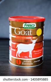 Auckland, New Zealand - May 22 2019: Tin Of Fresco Nutrition Goat Based Formula For Infants From Birth. 900gm Tin With Red Lid. Bronze Coloured Tin On Dark Kitchen Bench With Grey Background.