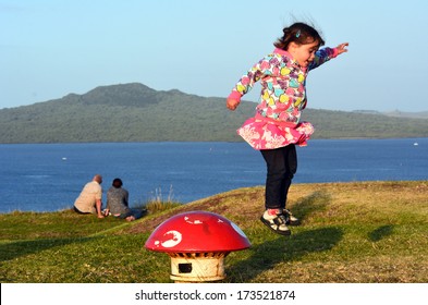 AUCKLAND, NZ - JAN 18:Child jump (Talya Ben-Ari age 3) near Rangitoto Island on Jan 18 2014.It's the most recent and the largest of the approximately 50 volcanoes of the Auckland volcanic field.