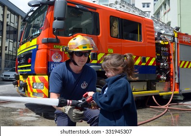 AUCKLAND  - OCT 27 2015:Firefighter and child (Talya Ben-Ari age 05) during Fire Safety Education day.Each year over 20,000 fires are attended by New Zealand Fire Service with about 5,000 house fires.